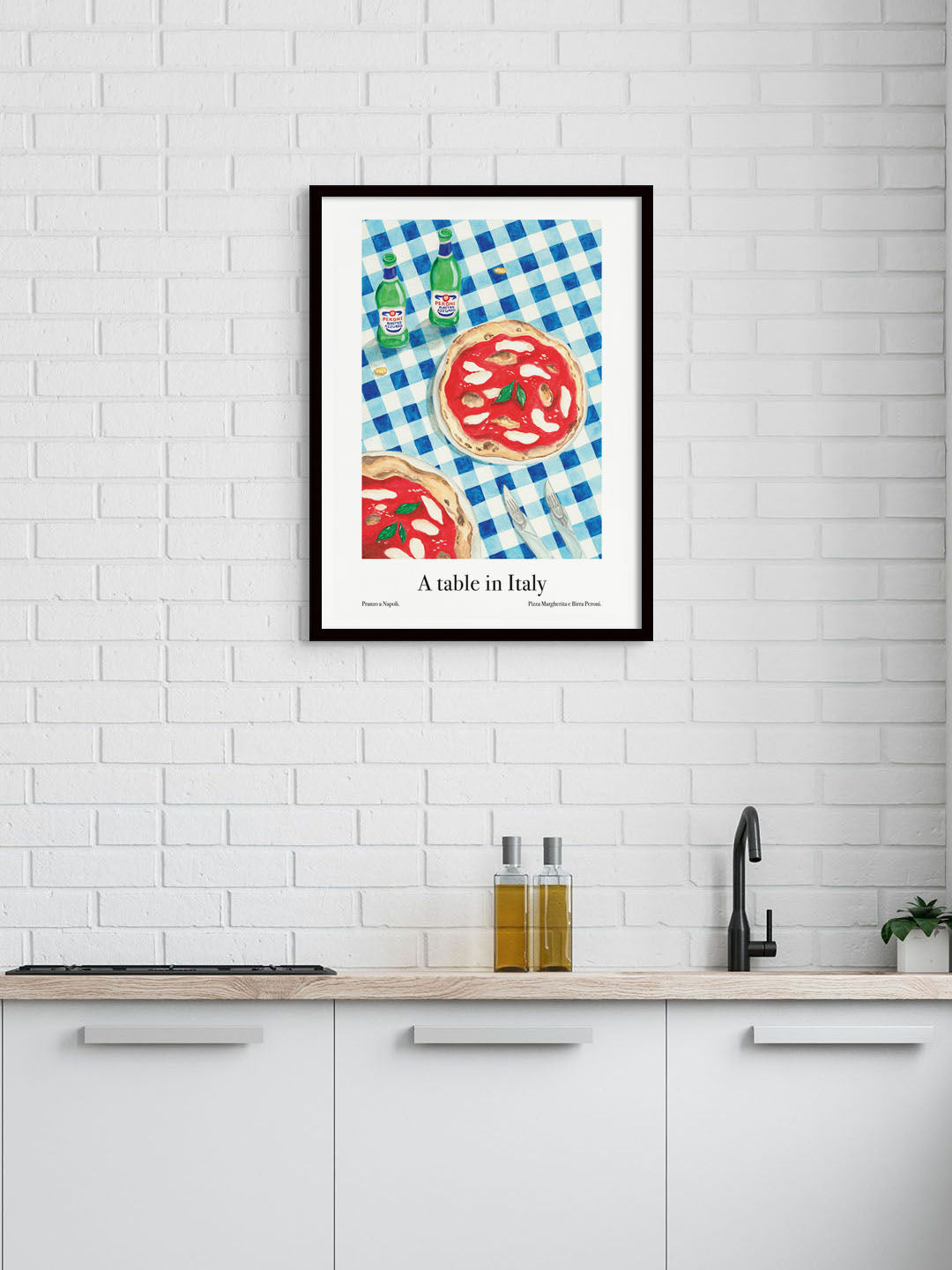A kitchen with an art poster of a table in Italy with pizza and Peroni beers on the wall