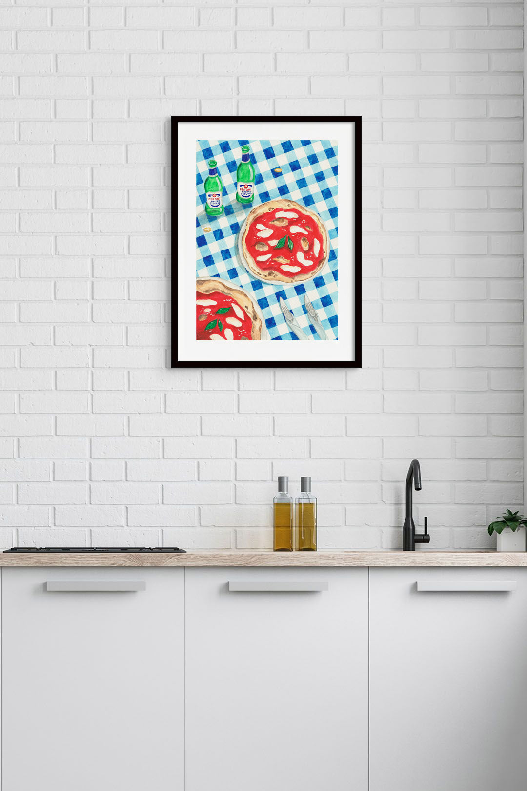 A kitchen with an art print of a table in Italy on the wall.