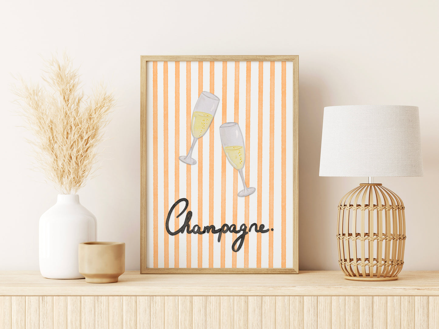 Framed artwork with champagne glasses and 'Champagne' text on a shelf with decor items.