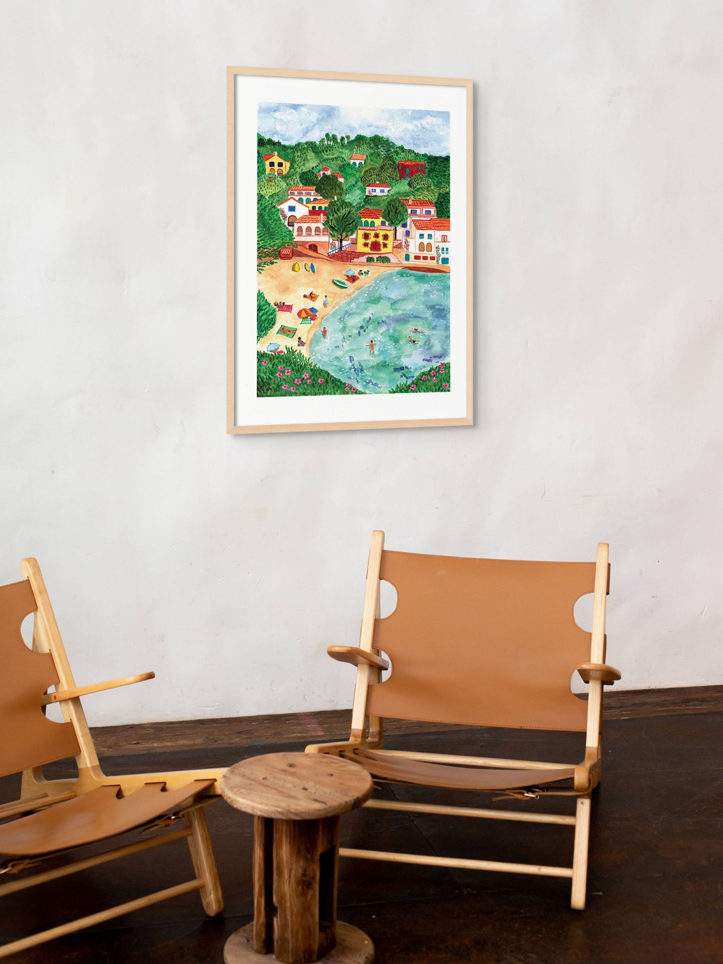A living room with an art print of a village in Catalonia, Spain on the wall.