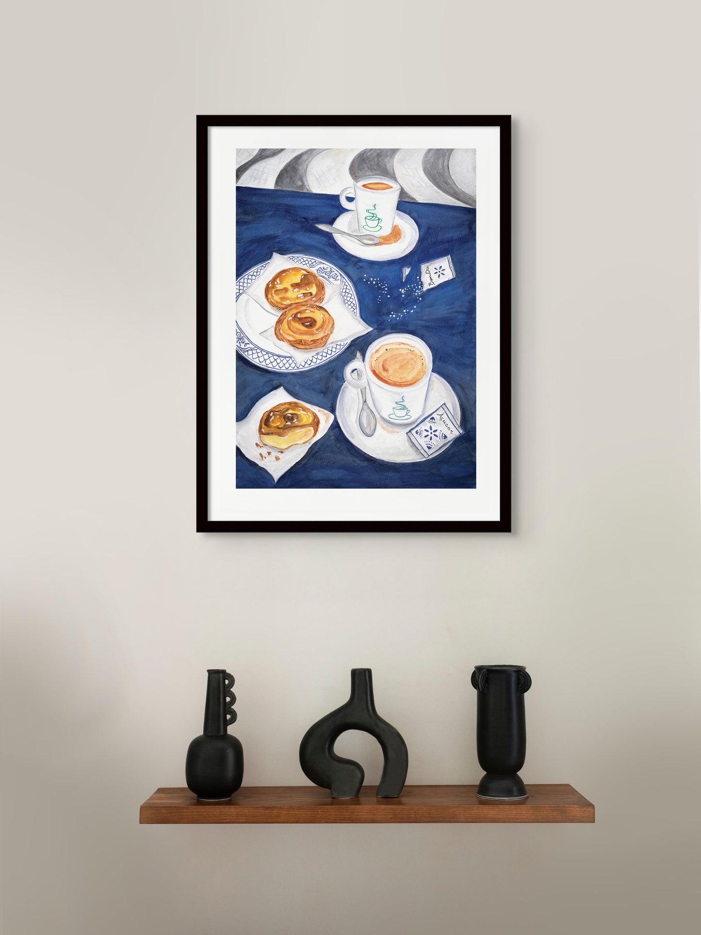 An art print of a table in Portugal with Portuguese tarts and coffee on a white wall.