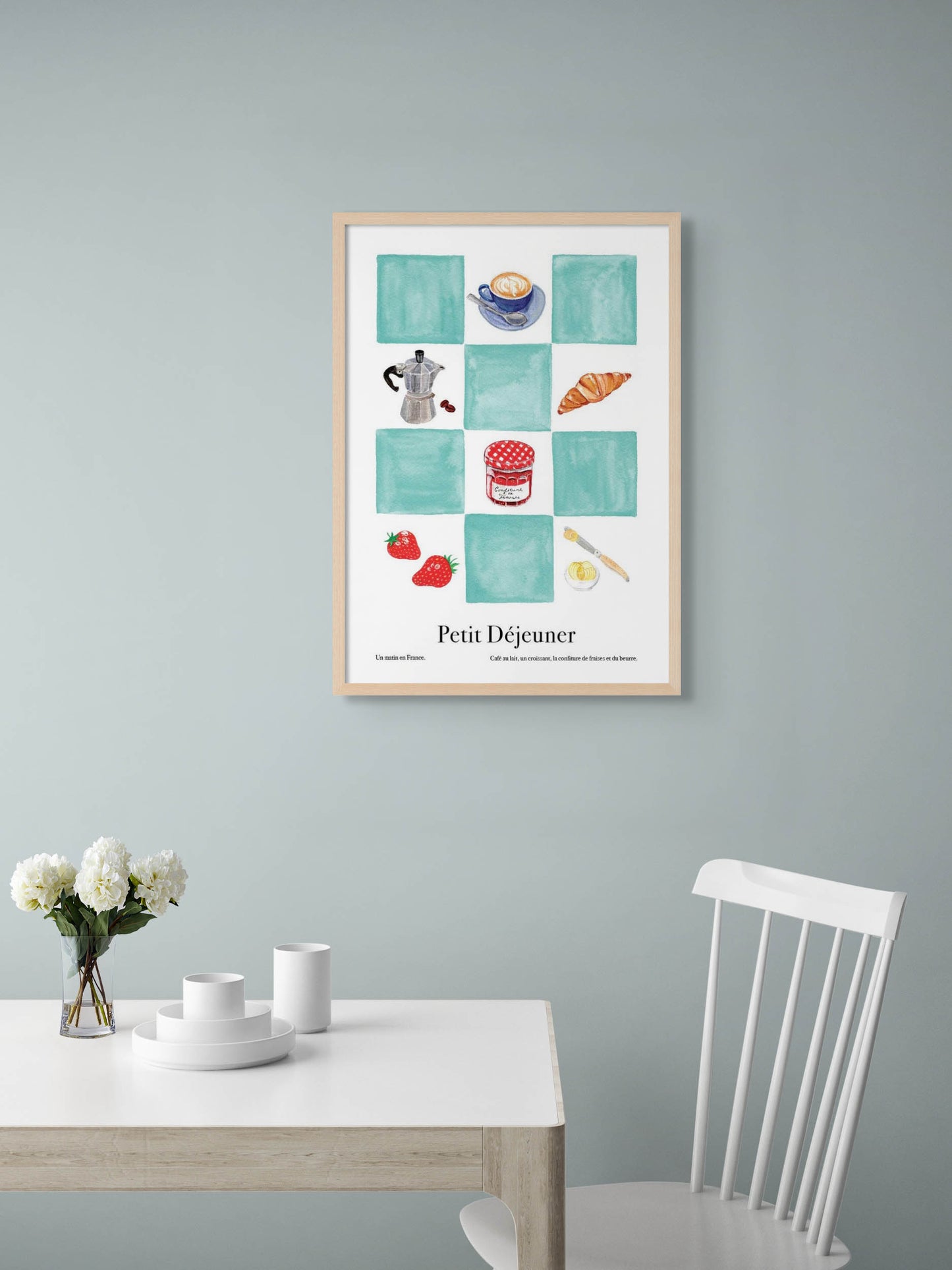 A dining room with an art poster with blue checkers and illustrations of coffee and croissants on the wall.