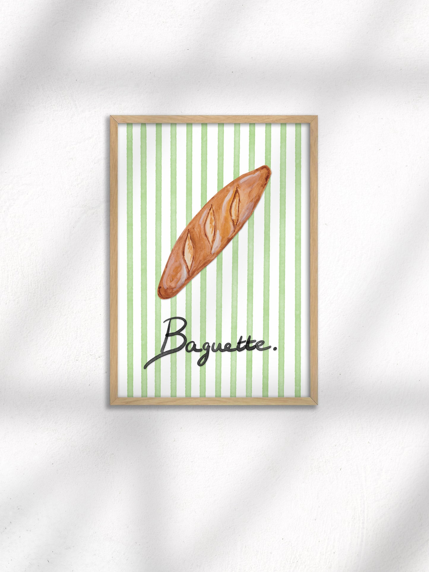 Framed artwork of a baguette on a green and white striped background