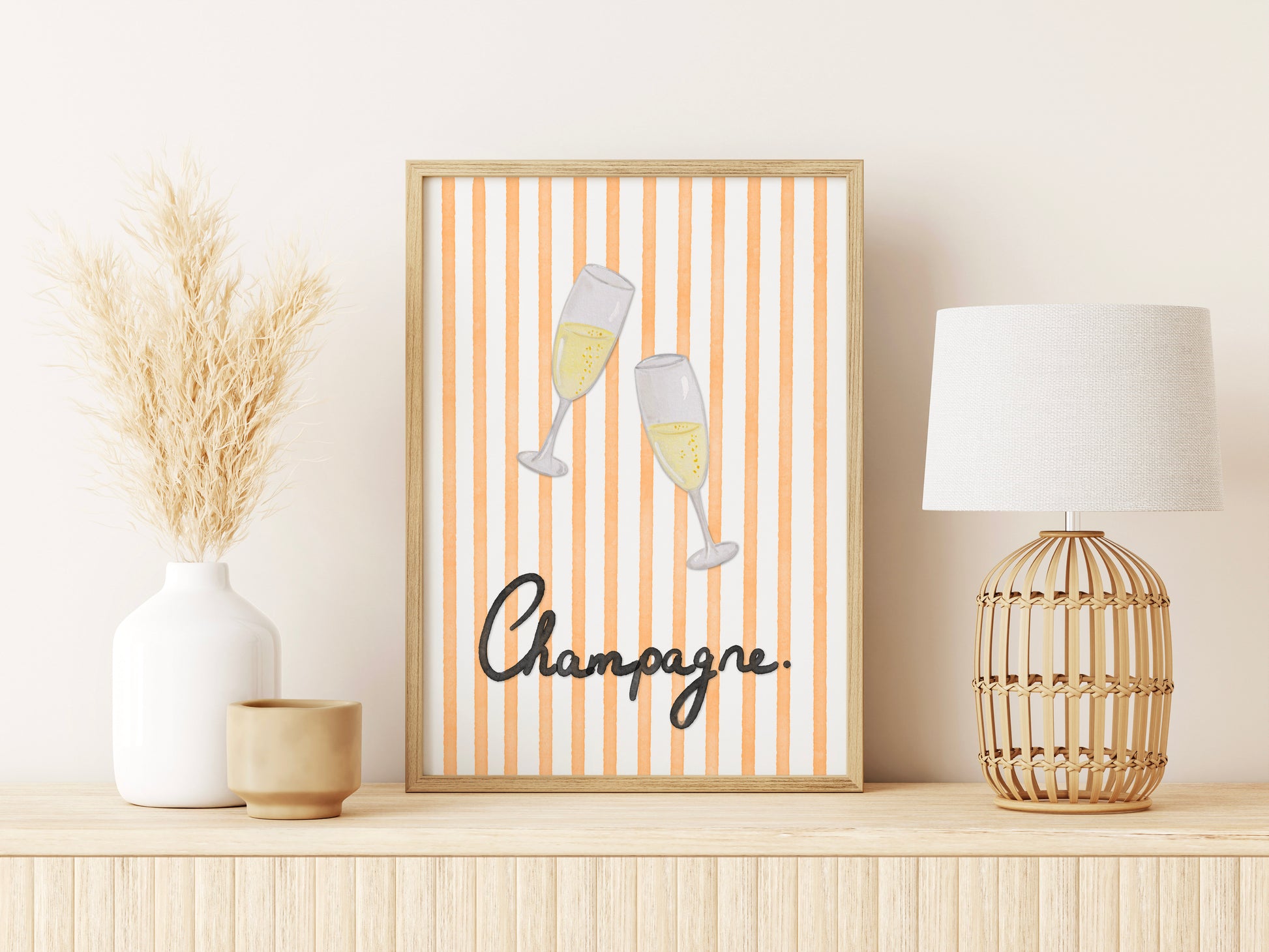 Framed artwork with champagne glasses and 'Champagne' text on a shelf with decor items.