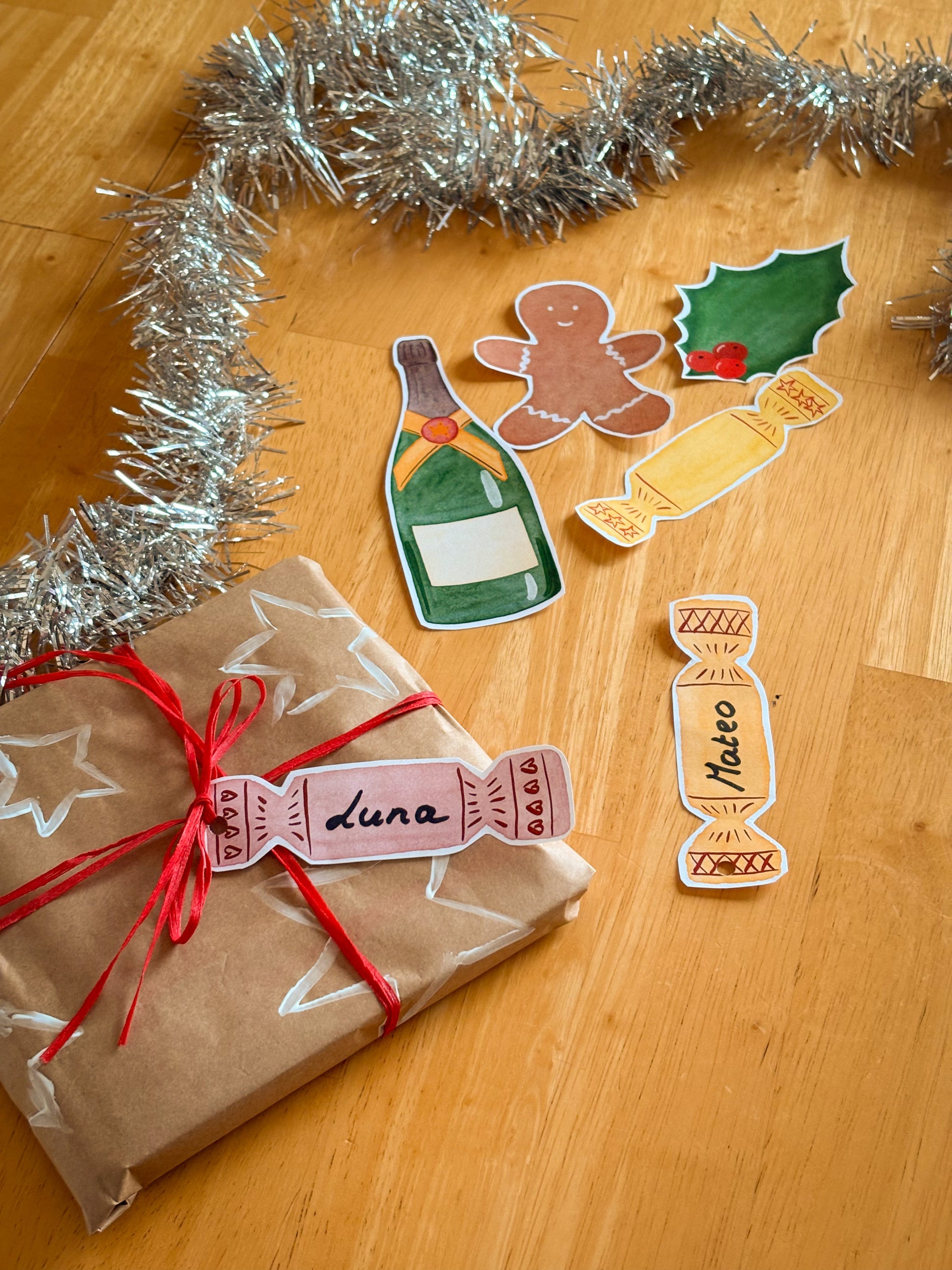 Gift wrapped in brown paper with red ribbon, surrounded by Christmas-themed elements on a wooden surface.