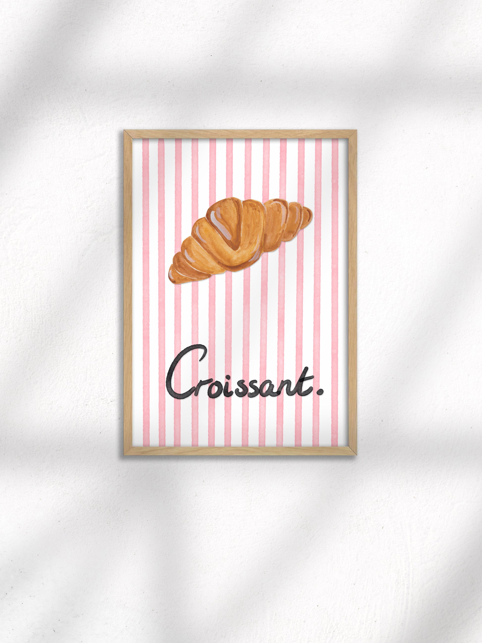 Framed artwork with a croissant illustration on a striped background