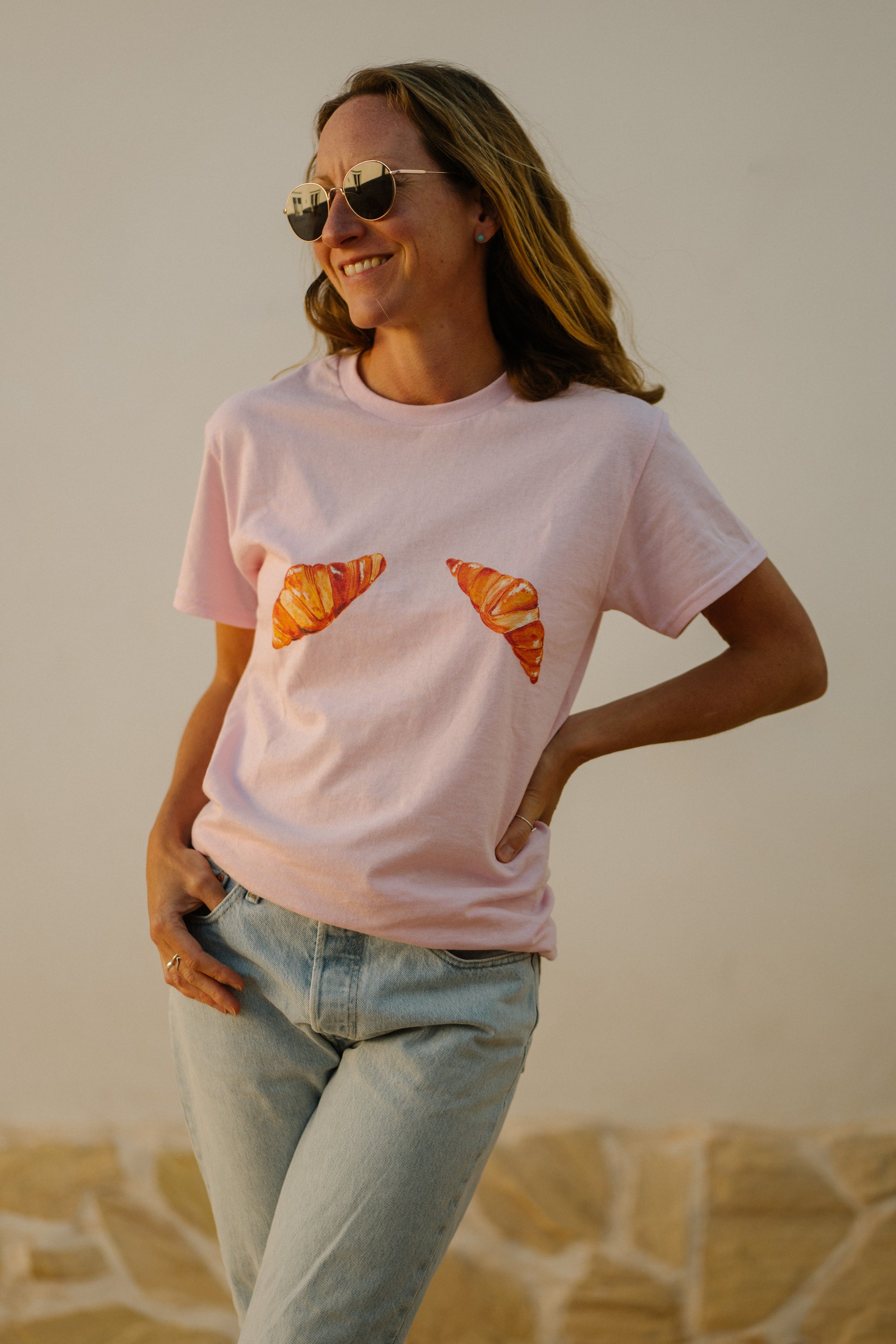 A girl wearing a pink t-shirt with hand painted croissants
