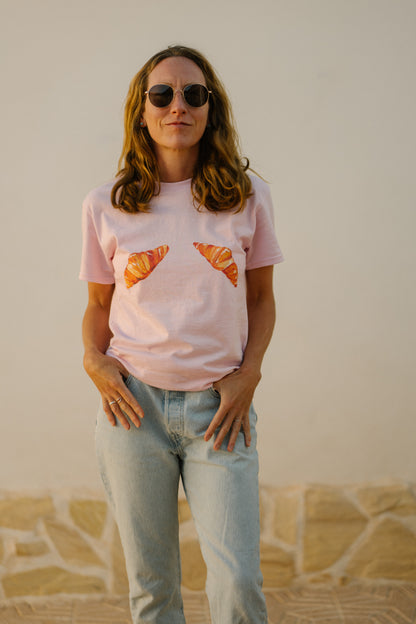 A girl wearing a pink t-shirt with hand painted croissants