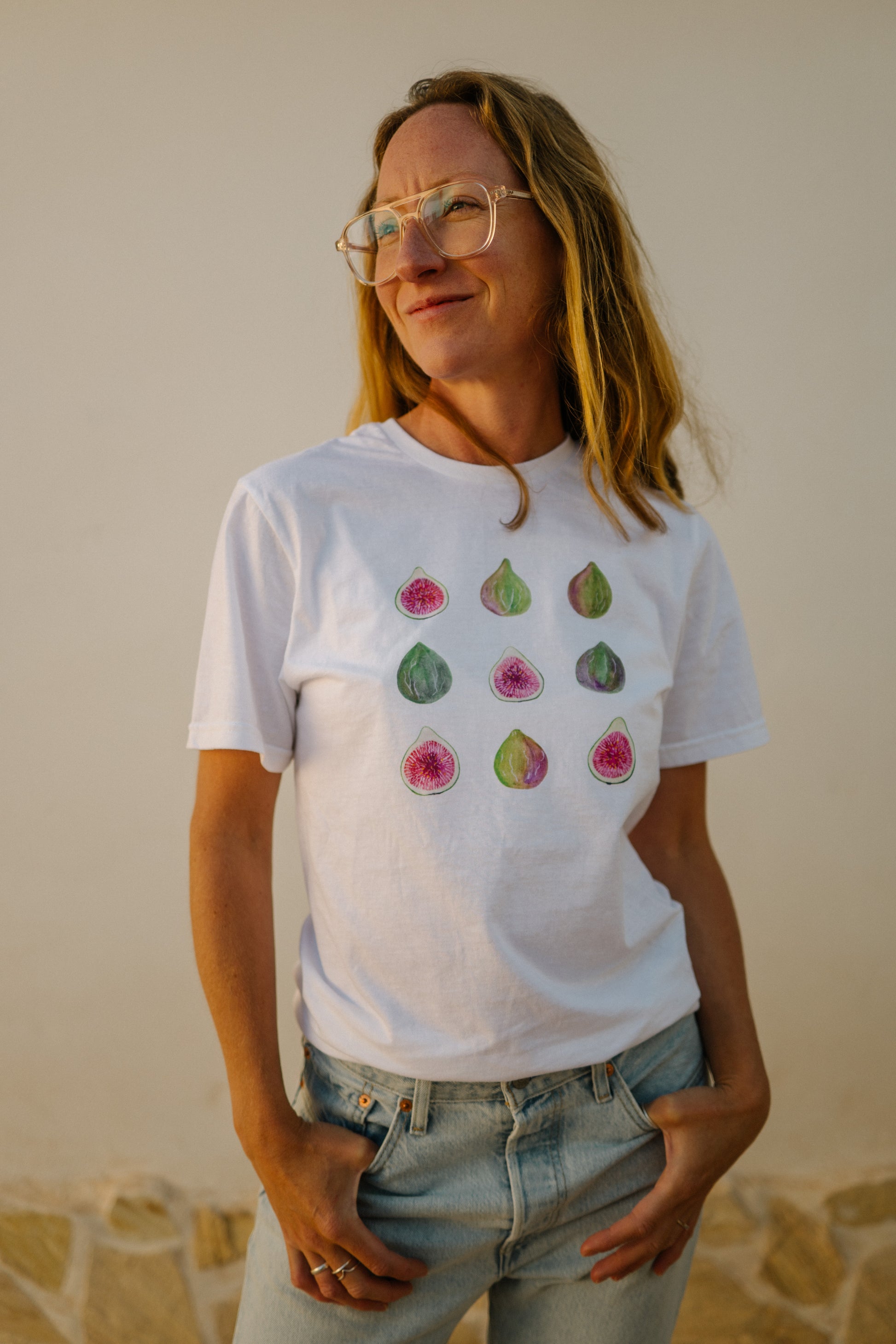 A woman wearing a white t-shirt with hand-painted figs