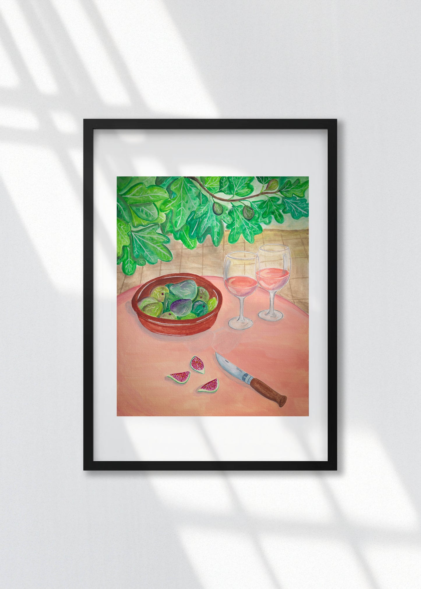 A framed art print of wine and figs on a table in a garden. 