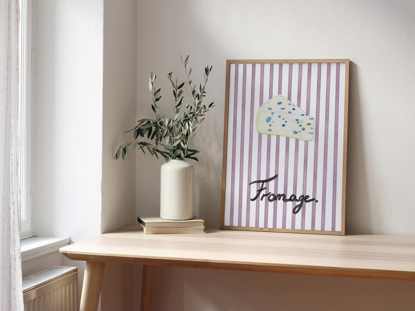 Framed artwork with striped design and 'Fromage' text on a wooden shelf.