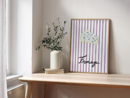 Framed artwork with striped design and 'Fromage' text on a wooden shelf.