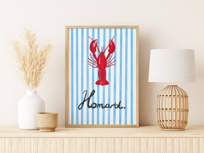 Framed artwork with a red lobster on a blue and white striped background, displayed on a shelf.