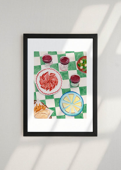 Framed artwork of a table with a checkered tablecloth, Spanish tapas and wine on a white wall.