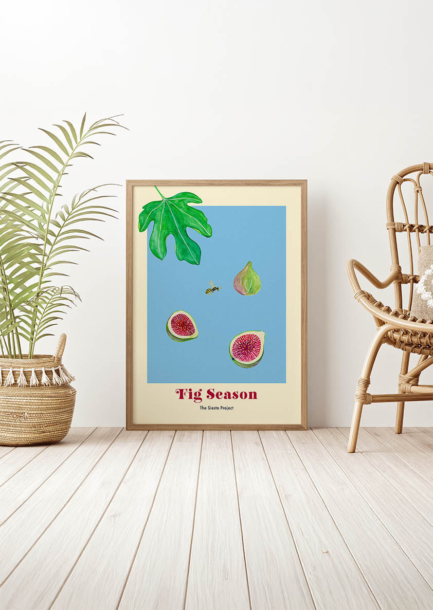 Framed artwork titled 'Fig Season' on a wall with a plant and chair in the background.