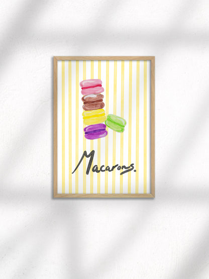 Framed artwork of colorful macarons on a yellow striped background