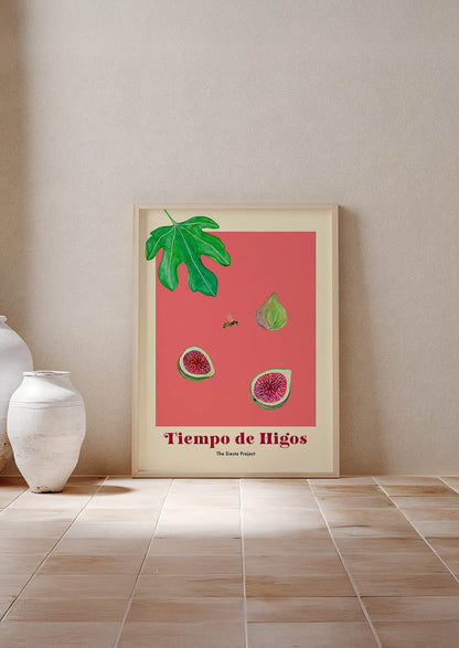 Framed artwork with fig illustration on a red background, leaning against a beige wall.